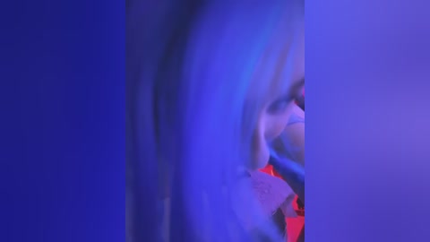 Media: Video of a blurred, abstract, neon-lit figure with a mix of blue and red hues, creating a dreamy, ethereal effect, possibly depicting a person in a nightclub.