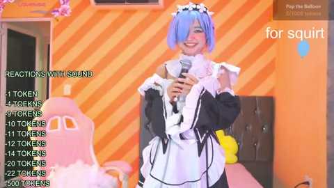 Media: Video of a cheerful woman in a maid costume, holding a microphone, with a colorful striped background and a pink chair. Text overlays show reactions and totems.