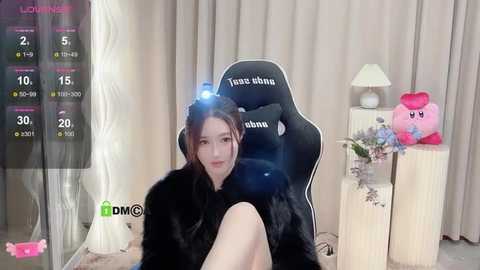 Media: A video shows a young Asian woman in a black dress, sitting in a gaming chair with a Kirby plush toy nearby, in a cozy room with beige curtains.