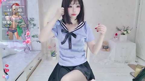 Media: Video of a young Asian woman with fair skin, black bob hair, and red lipstick, wearing a blue sailor school uniform, posing playfully in a bright, modern room with a large window and floral decorations.