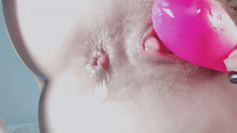 Video of a close-up of a woman's bare chest, showing a pierced nipple with a pink jewel, and a small amount of pubic hair.