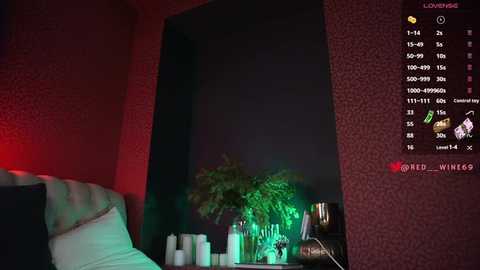 Media: A video of a dimly lit room with a green glow, featuring a potted plant, a bed with white pillows, and a red wall. A digital display shows stats like \"LOVE\" and \"WINS.\