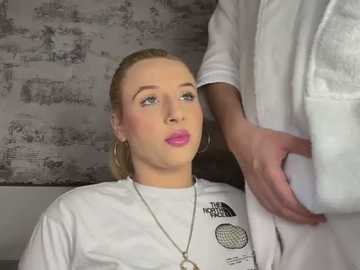 A video depicts a blonde woman with pink lipstick and hoop earrings, wearing a white T-shirt with a circular logo, sitting in a salon chair. A hand rests on her shoulder.