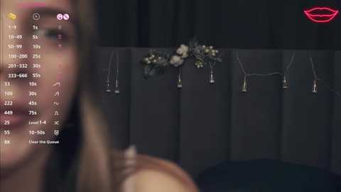 Media: A blurry video shows a woman's face on the left, with a detailed floral arrangement and candles on a dark background on the right.