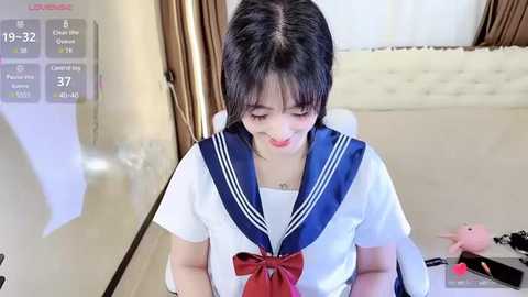 Media: Video of a young Asian woman with black hair in a white sailor school uniform, kneeling in a modern bedroom with a TV displaying a fitness app, and a stuffed pink pig nearby.