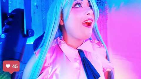 Media: Video of a young woman with long, pastel blue hair, wearing a white shirt and black tie, smiling joyfully under vibrant blue and pink lighting, set against a blurred background.