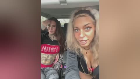 Media: Video of two women in a car; one with long blonde hair, wearing a black crop top, and another with long dark hair, wearing a red \"Juicy\" crop top.