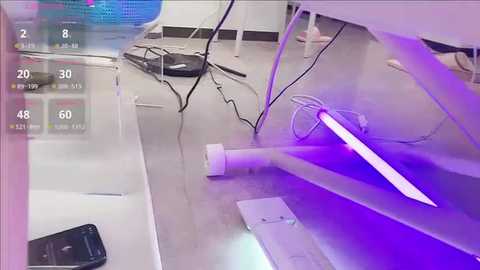 Video of a modern office space featuring a sleek, minimalist desk with white walls, a purple LED light strip, and a large, flat-screen monitor displaying a digital clock with times 2:08, 30, 60, and 48.