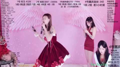 Video of a Chinese pop singer, dressed in a red velvet dress, singing on stage with angel wings, surrounded by a pink backdrop and Chinese text.