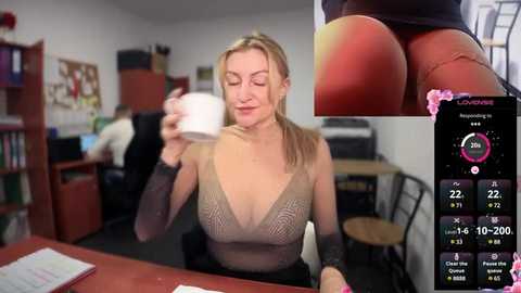 Media: Video of a blonde woman in a sheer top, holding a coffee cup, in a cozy office. Inset: close-up of her bare buttocks. Background: shelves, desk, and computer.