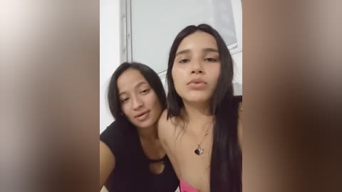 Media: A video of two young Asian women, one with long black hair, the other with shorter hair, taking a selfie indoors, wearing casual clothes.