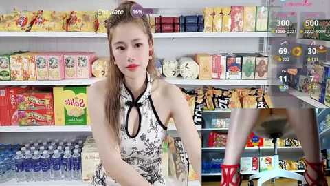 Media: Video of a fair-skinned woman with long blonde hair, wearing a sleeveless black and white patterned dress, standing in a brightly lit convenience store filled with snacks and beverages.