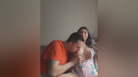 Media: Video of a tattooed, muscular man with short hair in an orange shirt performing oral sex on a woman with long hair in a pink shirt.