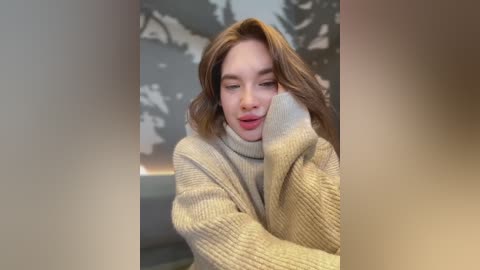 Media: A video of a young woman with fair skin, shoulder-length brown hair, and a soft smile, wearing a cozy beige knit sweater, leaning against a blurred, snow-covered forest background.