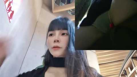 Media: Video of a young Asian woman with long, straight, dark hair and light skin, wearing a black choker and black top. She stands indoors, in front of a window, with a wooden ceiling visible in the background.