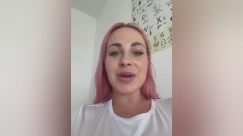 Media: A video of a young woman with pink hair, wearing a white top, standing indoors. The background features a white wall with a blackboard and mathematical equations.