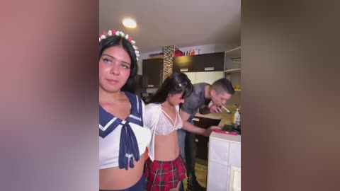 Media: A video of three young women in a kitchen, one with a sailor costume, another in a plaid skirt, and a third in a bra, all with flushed faces.