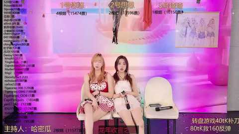 Media: Video of two Asian women, one with red hair and the other with brown hair, seated on a bench. They wear sleeveless dresses and hold microphones. Background features a vibrant, abstract, pink and purple digital art.