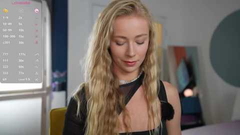 Media: A video of a blonde, fair-skinned woman with wavy hair, wearing a black dress, looking down at a smartphone with a colorful social media interface visible.