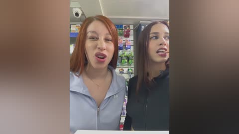 Media: Video of two women, one with red hair and the other with brown hair, in a convenience store, making faces.