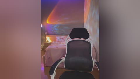 Media: Video of a dimly lit bedroom with a white gaming chair, a pink bed, and a colorful starry-night wall mural.