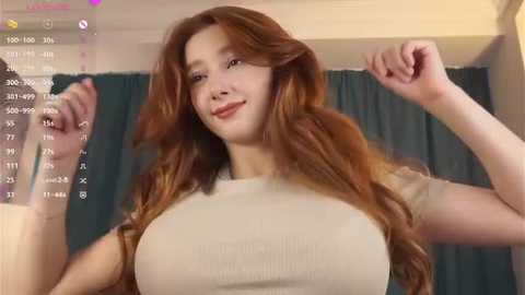 Media: A video of a light-skinned woman with long, wavy red hair, wearing a tight beige top that accentuates her large breasts, striking a victorious pose with her right arm raised.