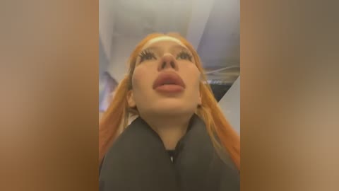 Media: Video of a fair-skinned woman with long, straight, orange hair, wearing dark lipstick, gazing upward, indoors, with blurred background.