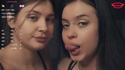 Media: Video of two young women with fair skin and dark hair, one licking the other's face, in a playful, intimate setting.