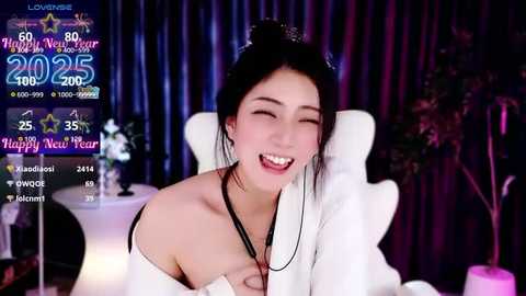 Media: A lively video features a smiling, fair-skinned Asian woman with black hair in a white off-shoulder top, celebrating the Chinese New Year in a dimly-lit room with festive decor.