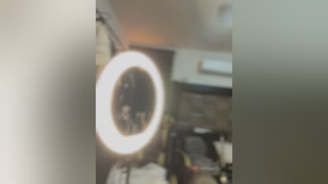 Media: A blurred video shows a large, round, bright light in the foreground, possibly a ring light. The background is indistinct, featuring a kitchen with a stove and cabinets, with an air conditioner above.