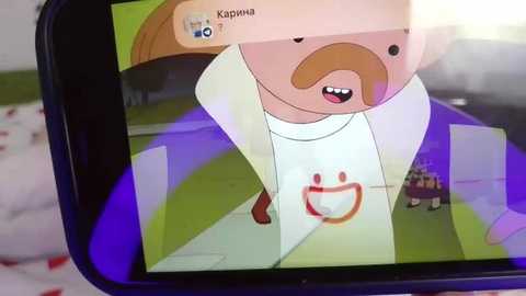 Media: Video of a smartphone screen showing a cartoon character with a big smile and a red circle on a white shirt, walking on a green field, with a snowy background and blurred objects.