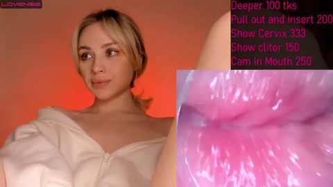 Media: Video of a blonde woman in a white shirt, looking to the left with a serene expression, against a warm orange background. A close-up of a pink, moist vagina is in the foreground.