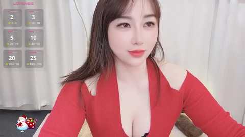 Media: Video of a fair-skinned, East Asian woman with straight, shoulder-length brown hair, wearing a red, off-the-shoulder top that reveals cleavage, smiling, with a digital timer display in the background.