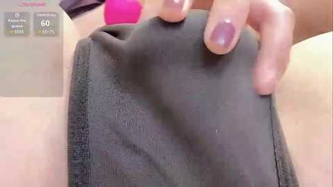 Media: A close-up video shows a hand pressing a grey fabric pouch, revealing a pink vibrator inside. The background includes a smartphone screen displaying health tracking data and a woman's arm.