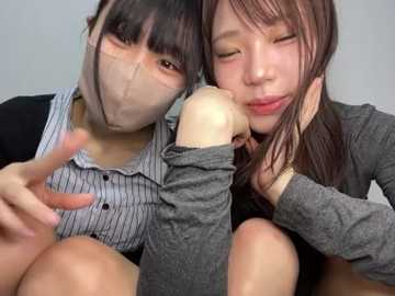 Media: Video of two East Asian women, one with a surgical mask, hugging in a casual setting, wearing striped and gray shirts, smiling warmly.