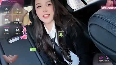 Media: A video of an Asian woman with long, dark hair, dressed in a black school uniform, smiling while seated in a car. The background shows a dashboard display with various app icons.