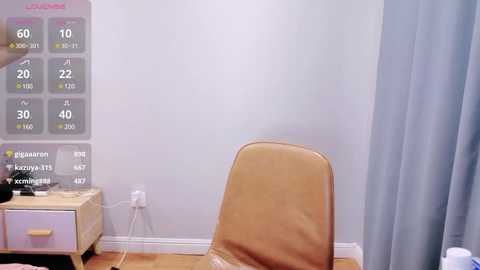 Media: A video of a minimalist bedroom with a beige leather chair, a white nightstand, and a digital thermometer on the wall, showing 66 degrees.