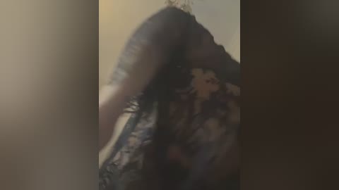 Media: A blurred video of a person with long, dark hair, wearing a black lace bodysuit, captured from a low angle, emphasizing the curves of their body.