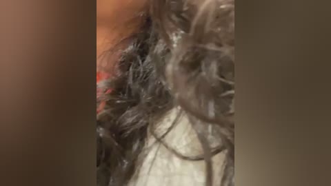 Media: Close-up video of a person's head, showing a thick mass of matted, black hair and a pale, injured scalp. The image has a blurry, grainy texture.