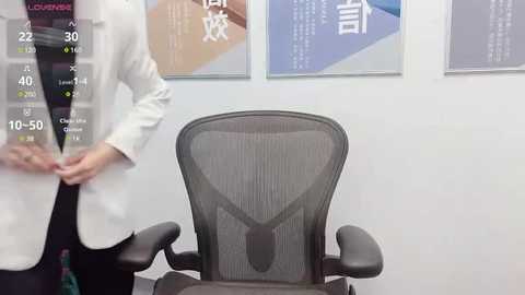 Media: Video of a medical office with a white-coated doctor adjusting a black mesh office chair against a light blue wall. Chinese text posters hang above.