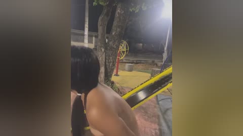 Media: A video of a person with long black hair, wearing a black top, walking away from a yellow and black caution tape in a dark, tree-lined park at night.