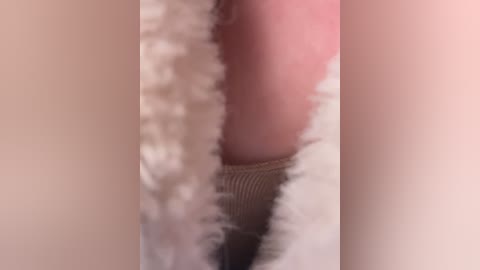 Media: A blurred video of a close-up of a person's thigh, showing light skin, a beige textured sock, and a hint of pink underwear. The image is out of focus, making it difficult to discern details clearly.