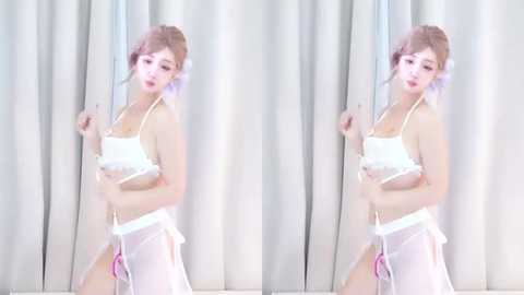 Media: Video of a slender, fair-skinned woman with light pink hair, wearing a sheer white bikini, standing against a white curtain backdrop, with a mirrored effect.