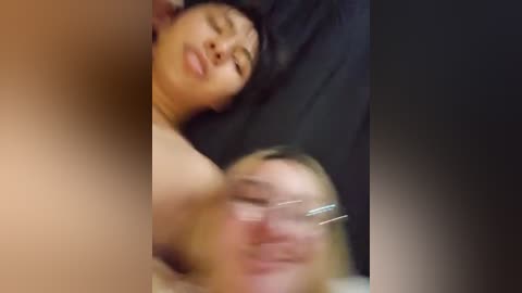 Media: A blurry, grainy video shows a young Asian woman with long black hair, lying on a black pillow, eyes closed, possibly sleeping.