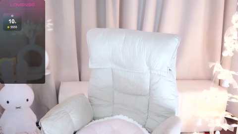 Media: Video of a plush, white leather recliner with a quilted backrest in a softly lit room with white curtains, a white teddy bear, and a white lamp.