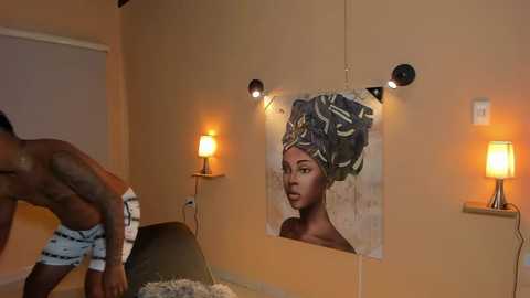 Media: Video of a room with a large painting of a Black woman with an elaborate Afro, two men in striped boxers, and warm lighting.