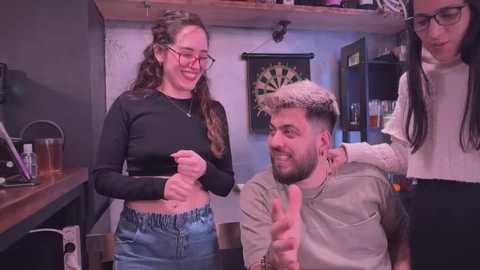 Media: Video of a woman in a black top and jeans, smiling with a man in a light shirt, both in a cozy bar.