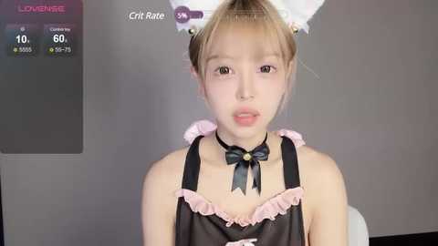 Media: Video of a young Asian woman in a pink bunny-themed maid outfit with a black bow tie, standing against a plain gray background.