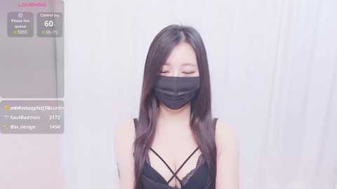 Media: Video of an East Asian woman with long, straight black hair, wearing a black face mask, black lace-trimmed bralette, and a white background. Text overlay includes streaming platform details.