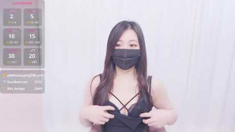 Media: Video of an Asian woman with long black hair, wearing a black lace bra and face mask, lifting her shirt, against a white background.